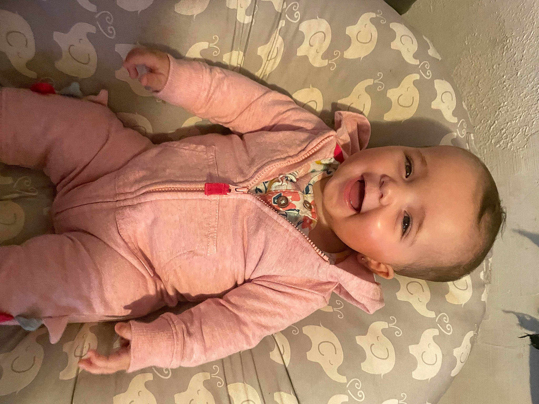 Marianna is registered to the contest to win money with this photo: baby, baby_toddler_clothing, cheek, chin, comfort, eye, finger, gesture, hand, head, human_body, joy, linens, mouth, nose, person, pink, skin, sleeve, smile
