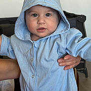 Aiden joined the competition — help win amazing prizes! baby, child, hood, blue_clothing, person, face, hand, indoor, portrait, cute, expression, apparel, infant, young_child, skin, eyes, mouth, sleeve, button, holding