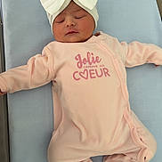 Ayrah a rejoint le concours — aidez-le/la à gagner de superbes lots ! baby, newborn, infant, sleeping, headband, bow, pink_onesie, footed_pajamas, clothing, lying_down, mattress, hospital_bassinet, closed_eyes, peaceful, portrait, tiny_feet, soft_texture, cute, heart_logo, crib