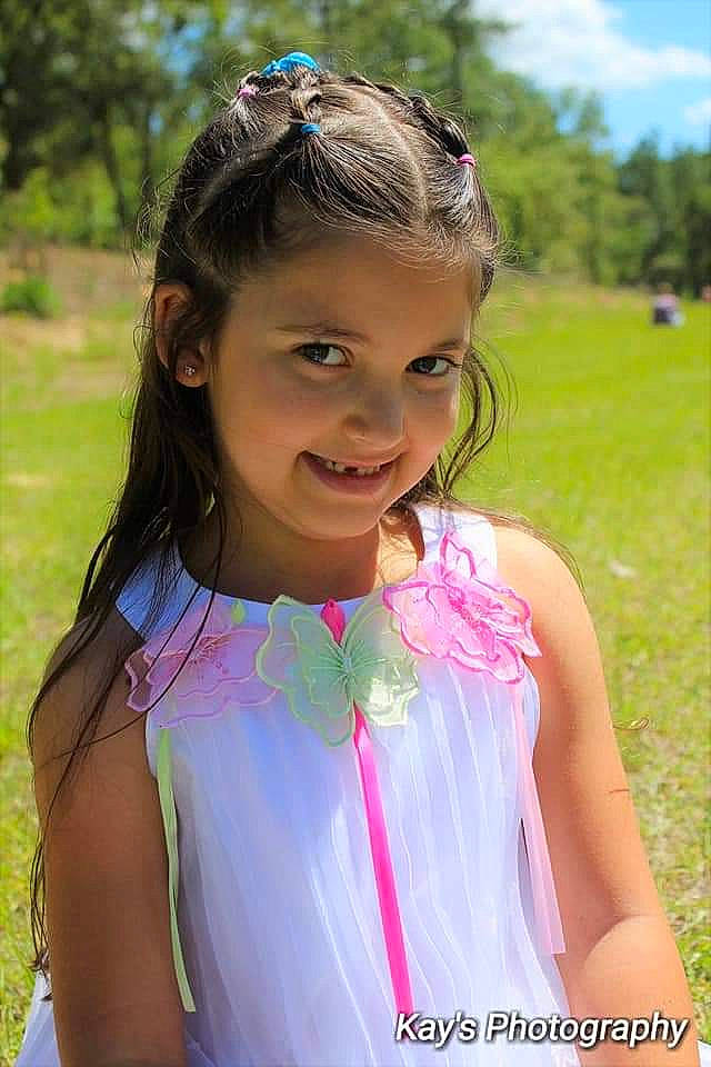 Francesca is registered to the contest to win money with this photo: brown_hair, child, child_model, dress, fashion_accessory, grass, hair, hair_accessory, hairstyle, happy, headband, joy, long_hair, neck, person, pink, smile, summer