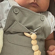 Izak participe au concours pour gagner de l'argent avec cette photo : adult, baby, blue_eyes, child, closeup, clothing, cute, expression, face, grey_outfit, hand, holding, indoor, infant, pacifier_clip, person, portrait, skin, soft_light, wooden_beads