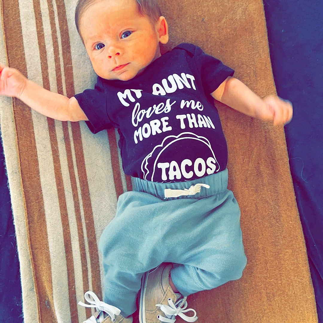 Robert James is registered to the contest to win money with this photo: baby, clothing, couch, cushion, face, footwear, furniture, head, homedecor, jeans, pants, person, photography, portrait, shoe, shorts, sitting, sneaker, t_shirt, wood