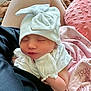 baby, newborn, sleeping, hat, mittens, white_clothing, blanket, pink_blanket, soft_texture, closeup, infant, peaceful, resting, cute, cozy, person, skin, face, small_child, indoors