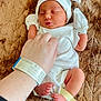 newborn, baby, infant, white_clothing, mittens, hat, hospital, hospital_wristband, hand, skin, bed, blanket, soft_texture, peaceful, sleeping, tiny_feet, closeup, person, resting, caring