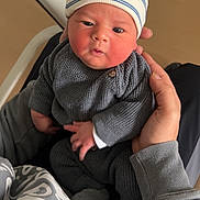 Eden participe au concours pour gagner de l'argent avec cette photo : baby, infant, hat, knitwear, gray_clothing, person, hand, holding, indoor, closeup, face, cute, newborn, cozy, sitting, portrait, child, warm, casual, expression