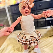 Harper Ann is registered to the contest to win money with this photo: baby, infant, headband, bow, dress, skirt, socks, hands, holding_hands, smile, happy, portrait, blanket, dresser, furniture, indoor, shallow_depth_of_field, clothing, toys, candid