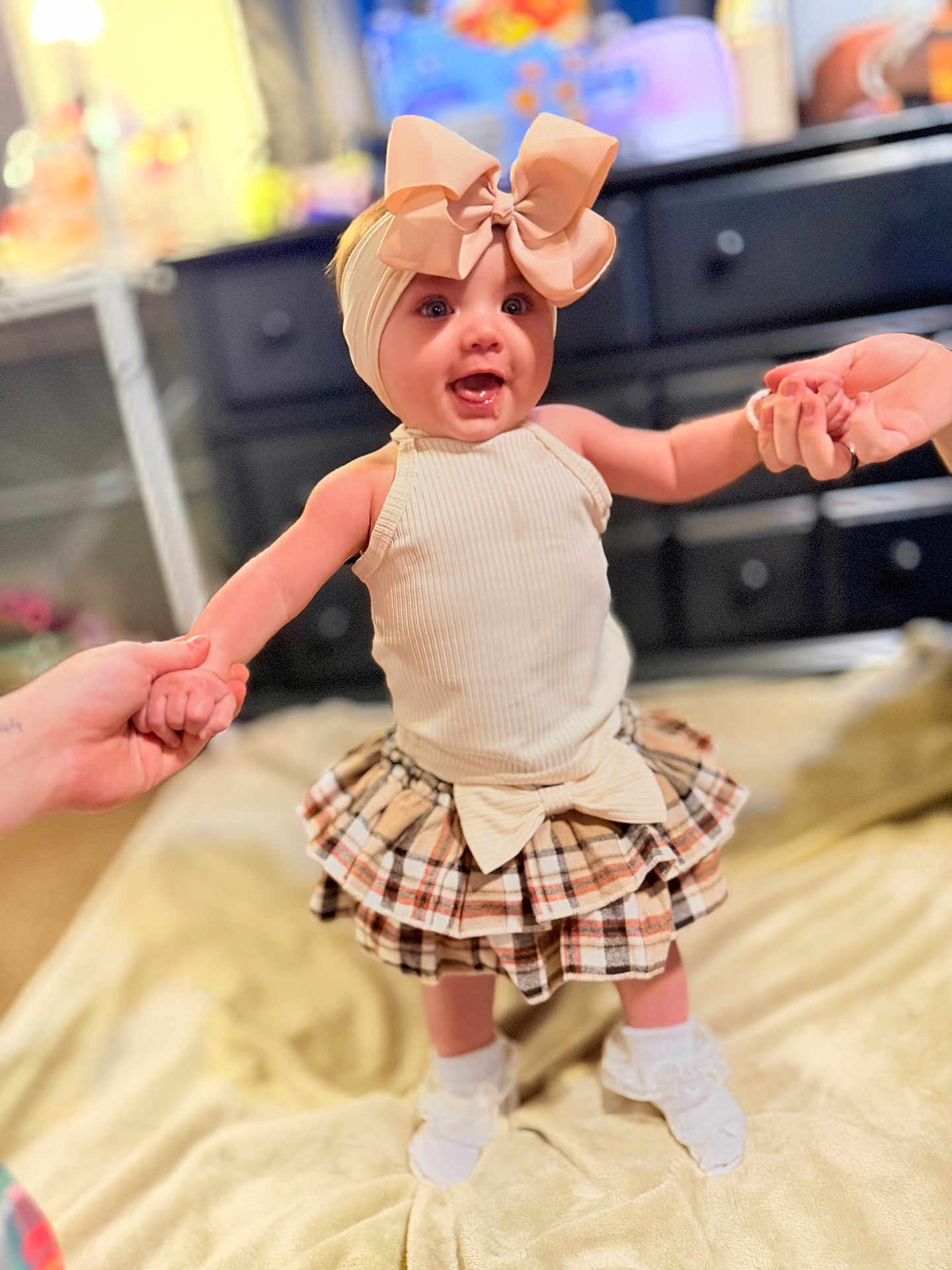 Harper Ann is registered to the contest to win money with this photo: baby, infant, headband, bow, dress, skirt, socks, hands, holding_hands, smile, happy, portrait, blanket, dresser, furniture, indoor, shallow_depth_of_field, clothing, toys, candid
