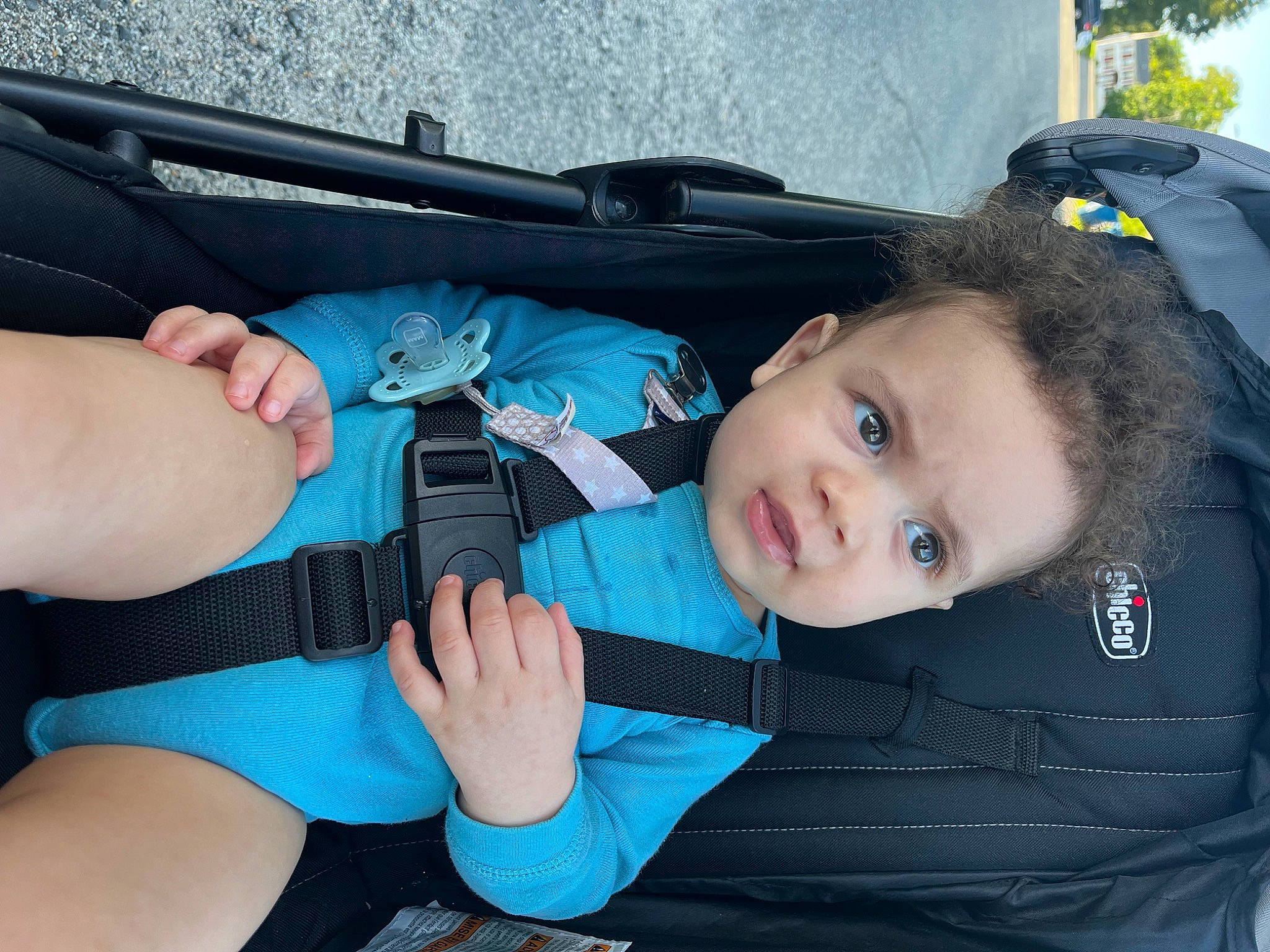 Joshua is registered to the contest to win money with this photo: auto_part, baby_products, baby_toddler_clothing, bumper, car_seat, child, comfort, electric_blue, fashion_accessory, finger, gesture, lap, nail, person, sitting, skin, sock, thumb, toddler, windshield