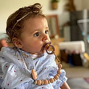 Cassie Anna June a rejoint le concours — aidez-le/la à gagner de superbes lots ! baby, pacifier, curly_hair, headband, shirt, heart_pattern, indoor, portrait, child, clothing, cute, person, young_child, face, expression, beads, soft_light, focus, closeup, infant