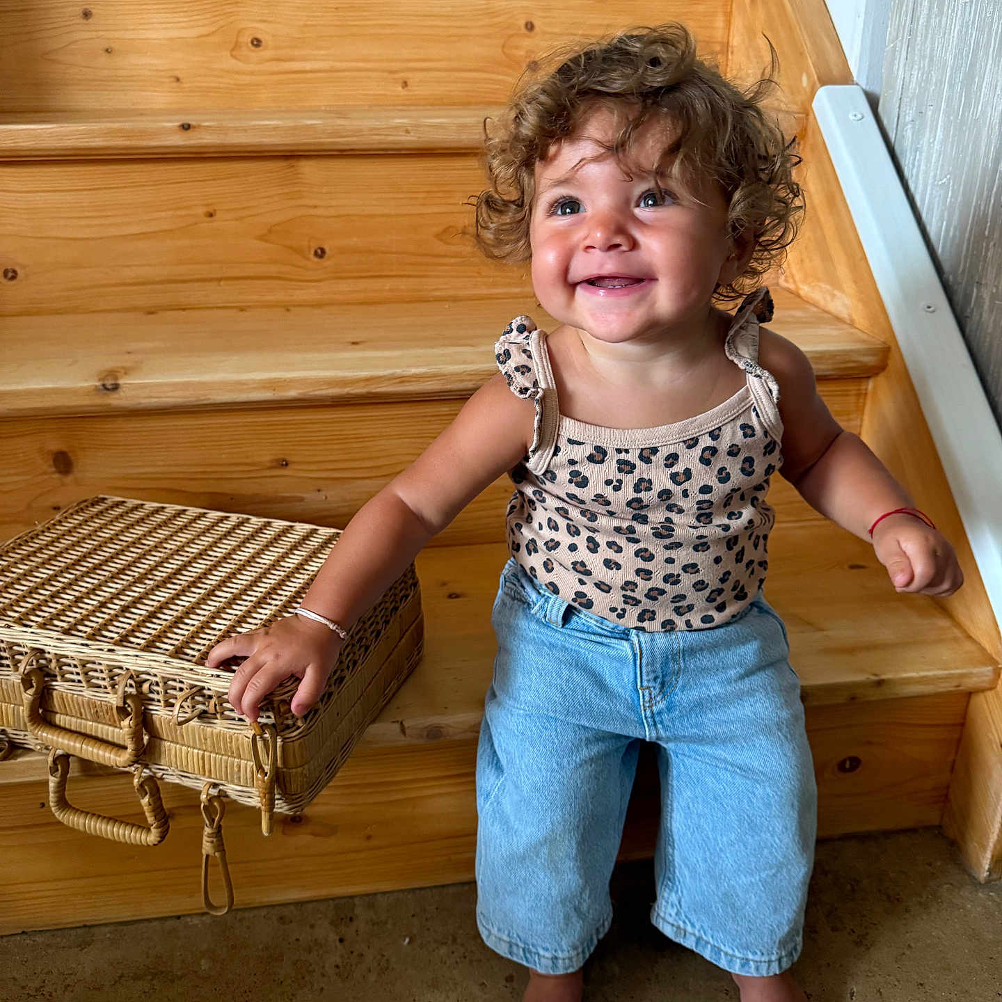 Cassie Anna June a rejoint le concours — aidez-le/la à gagner de superbes lots ! barefoot, basket, casual_clothing, child, curly_hair, cute, denim_pants, floor, happy, home, indoor, light_skin, natural_light, person, portrait, sitting, smiling, tank_top, toddler, wooden_stairs