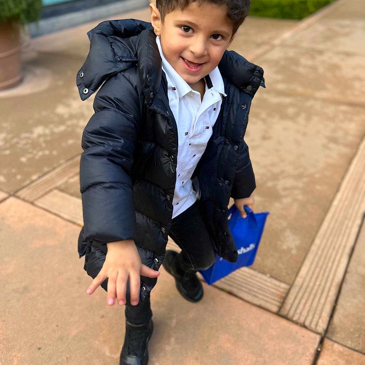 Hamzah Ali Saleh is registered to the contest to win money with this photo: black_boots, black_jacket, blue_bag, boy, building, casual_clothing, child, curb, daylight, greenery, happy, outdoor, pavement, person, playful, sidewalk, smiling, walking, white_shirt, window