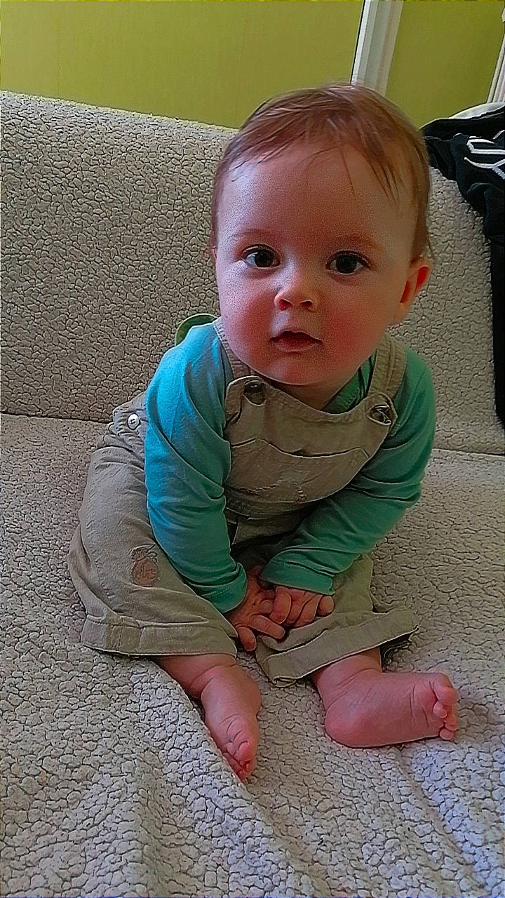 énaël participe au concours pour gagner de l'argent avec cette photo : arm, baby, baby_toddler_clothing, barefoot, cheek, child, comfort, finger, floor, flooring, foot, hair, iris, mouth, nose, person, sitting, skin, sleeve, thumb