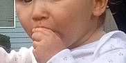 Alaeleea is registered to the contest to win money with this photo: baby, child, face, hand, headband, pink, outdoor, window, house, clothing, long_sleeve, person, infant, expression, cute, young, skin, portrait, sucking_hand, closeup