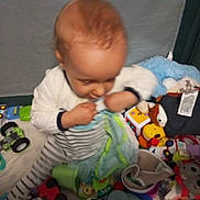 Louka participe au concours pour gagner de l'argent avec cette photo : baby, blanket, child, closeup, clothing, colorful, fabric, face, floor, hand, head, indoor, infant, messy, playpen, playtime, sitting, soft_toy, striped_clothing, toys