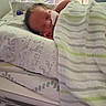 newborn, baby, hospital, crib, blanket, sleeping, nasal_tube, bedding, animal_print, striped_blanket, infant, medical, peaceful, child, bed, indoors, healthcare, cute, resting, soft