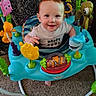 activity_jumper, baby, bright, carpet, child, clothing, colorful, cute, entertainment, face, fun, happy, indoor, infant, patterned_background, person, playful, sea_creatures, smiling, toys