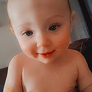 Liam is registered to the contest to win money with this photo: baby, child, infant, face, skin, blue_eyes, smile, indoor, curtains, couch, chubby, close_up, person, young, cute, happy, portrait, sitting, furniture, head