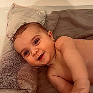 Ayden participe au concours pour gagner de l'argent avec cette photo : baby, infant, towel, bathtub, smile, wet_hair, face, hand, arm, eyes, portrait, bath, skin, soft_texture, pillow, happy, playful, cute, water, indoors