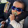 airbag_warning, baby, car_interior, car_seat, child, closeup, denim, hair, hand, infant, onesie, pacifier, plush_toy, portrait, reflection, safety_label, seatbelt, sunglasses, travel, window