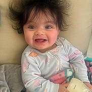 Aviah is registered to the contest to win money with this photo: baby, child, smile, milk_bottle, blanket, hair, happy, indoor, clothing, person, face, cute, infant, cozy, sitting, home, portrait, soft, young, joyful