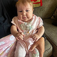 Oakley joined the competition — help win amazing prizes! baby, infant, pink_clothing, pajamas, bow, blanket, couch, person_holding_baby, hand, face, smiling, indoor, home, soft_toys, cartoon_character, minnie_mouse, cute, child, portrait, cozy