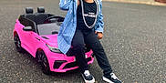 Alyssa Nevaeh joined the competition — help win amazing prizes! child, toy_car, pink, beaded_hair, necklace, jean_jacket, black_clothing, sneakers, outdoor, asphalt, suburban, house, trees, playful, smiling, portrait, daytime, casual, street, young_child