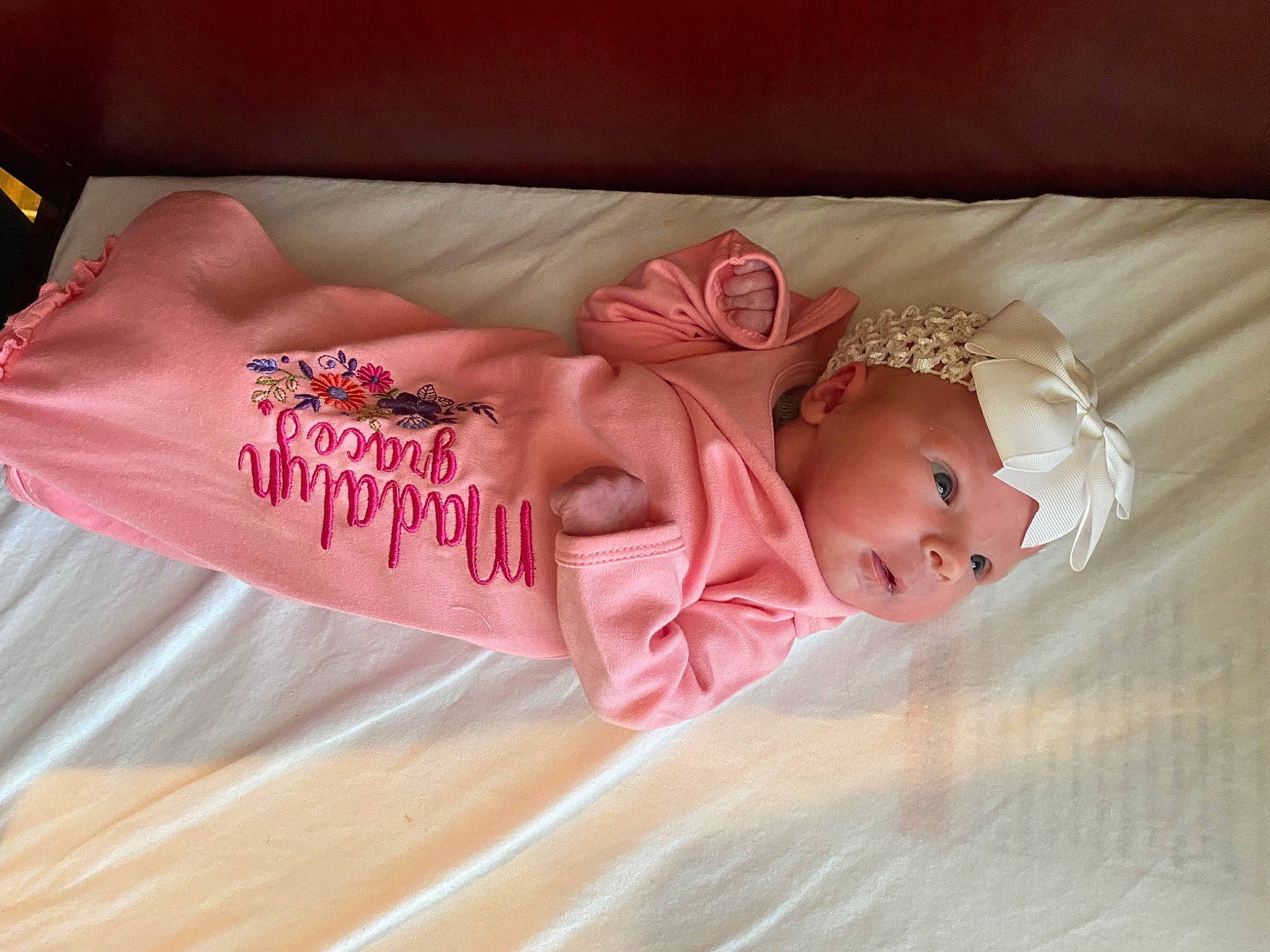 Madalyn is registered to the contest to win money with this photo: baby, baby_toddler_clothing, child, comfort, fashion_accessory, font, hair_accessory, headband, headpiece, headwear, jewellery, linens, magenta, pattern, peach, person, petal, pink, product, sleeve