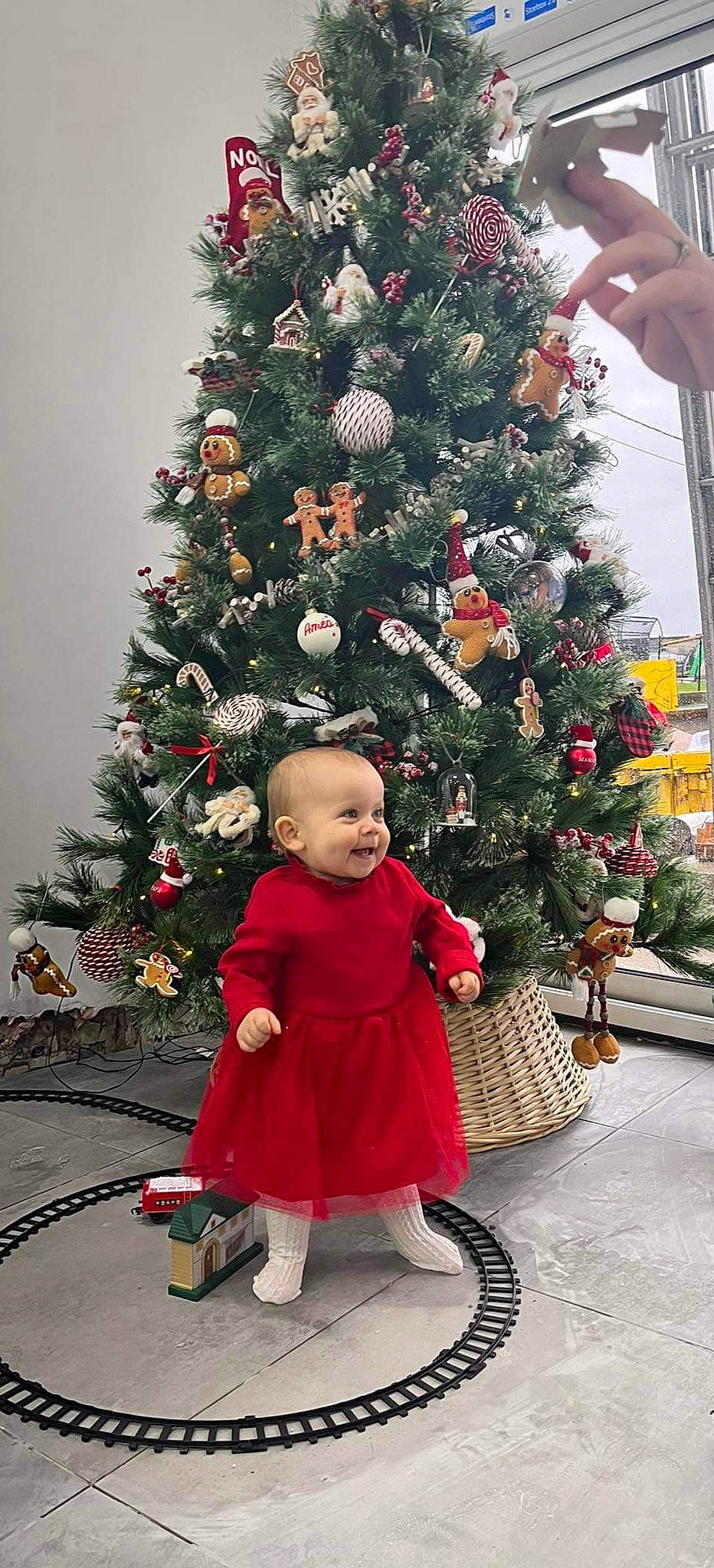 Céleste participe au concours pour gagner de l'argent avec cette photo : branch, christmas, christmas_decoration, christmas_eve, christmas_ornament, christmas_tree, event, evergreen, holiday, holiday_ornament, leaf, ornament, people, person, plant, snapshot, standing, toddler, tree, winter