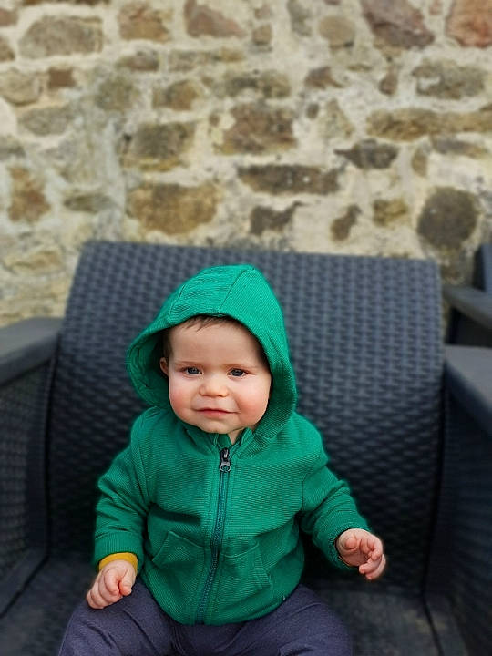 Maxence participe au concours pour gagner de l'argent avec cette photo : baby, baby_toddler_clothing, cap, child, clothing, comfort, couch, fun, grass, headgear, headwear, jacket, leisure, person, photograph, sitting, sleeve, toddler, tree, winter