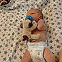 baby, infant, blanket, star_pattern, diaper, pacifier, plush_toy, socks, lying_down, bedroom, skin, newborn, comfort, soft_toy, cute, child, sleepwear, resting, baby_girl, baby_boy