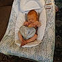 baby, newborn, infant, baby_rocker, bib, cushion, indoor, carpet, floor, sleeping, peaceful, infant_clothing, baby_boy, baby_seat, baby_sleeping, head, small_hands, small_feet, soft_lighting, home