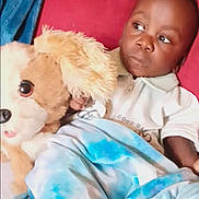 Savior joined the competition — help win amazing prizes! toddler, child, stuffed_animal, plush_toy, blanket, blue_blanket, tie_dye, red_couch, indoor, casual_clothing, white_shirt, serious_expression, young_child, relaxed, home_interior, person, furniture, soft_toy, comfort, resting