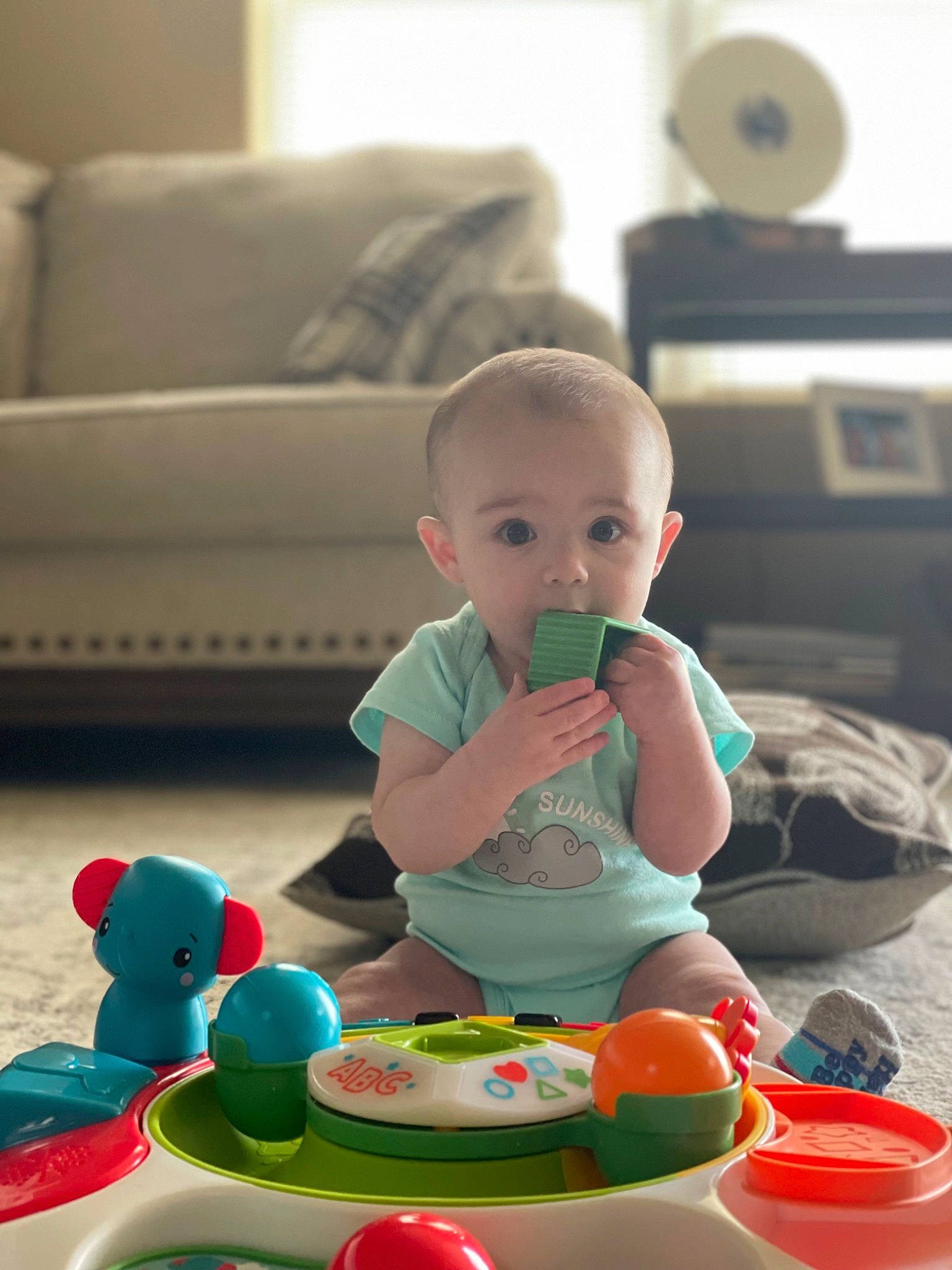 Daxton joined the competition — help win amazing prizes! baby, baby_playing_with_toys, baby_toddler_clothing, child, comfort, couch, drinkware, event, flooring, fun, leisure, person, photograph, play, product, room, sitting, snapshot, surprise, toddler