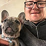 Oscar Cotton is registered to the contest to win money with this photo: animal, casual, close_up, collar, companion, cute, dog, face, french_bulldog, glasses, hand, holding, hoodie, indoor, man, pet, portrait, puppy, smile, zipper