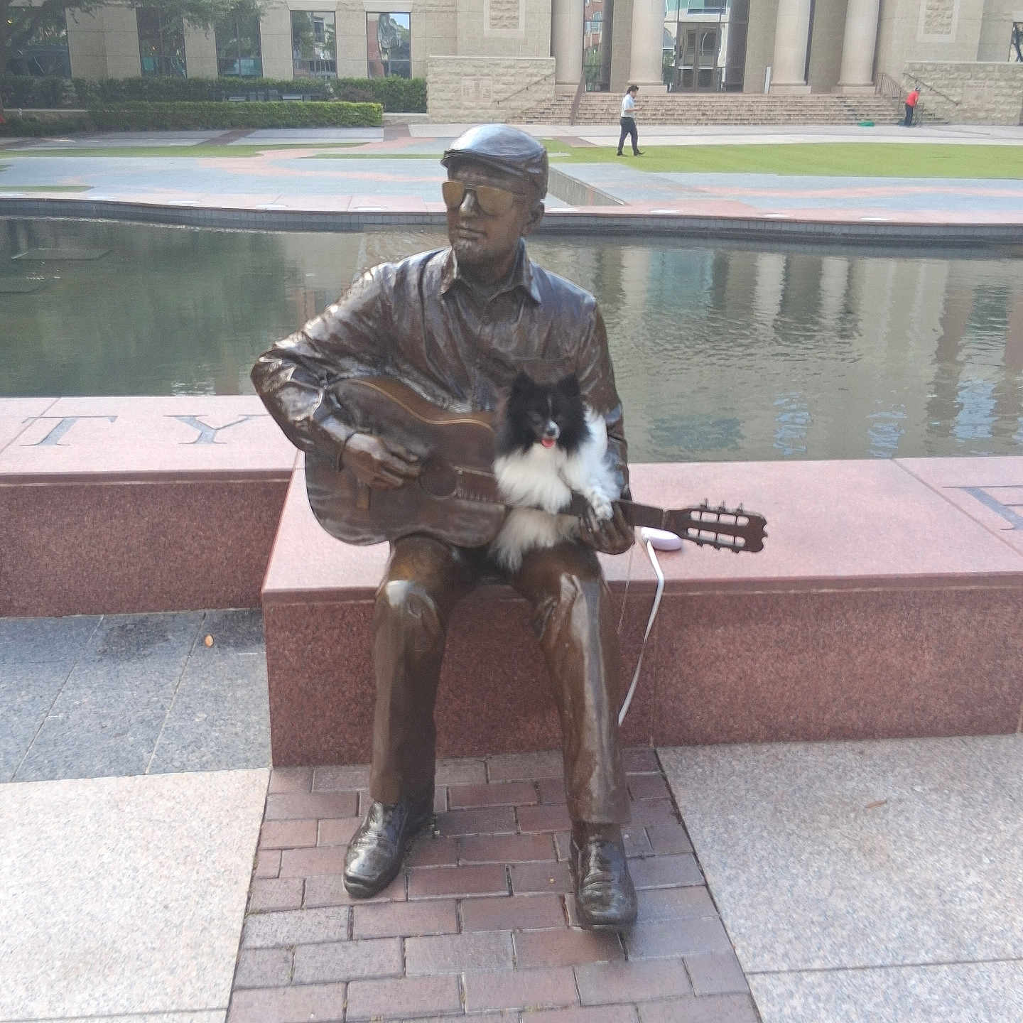 Drama Rose is registered to the contest to win money with this photo: bench, bronze, building, casual, daytime, dog, grass, guitar, leisure, music, outdoor, person, pet, pond, reflection, sculpture, sidewalk, statue, tree, urban