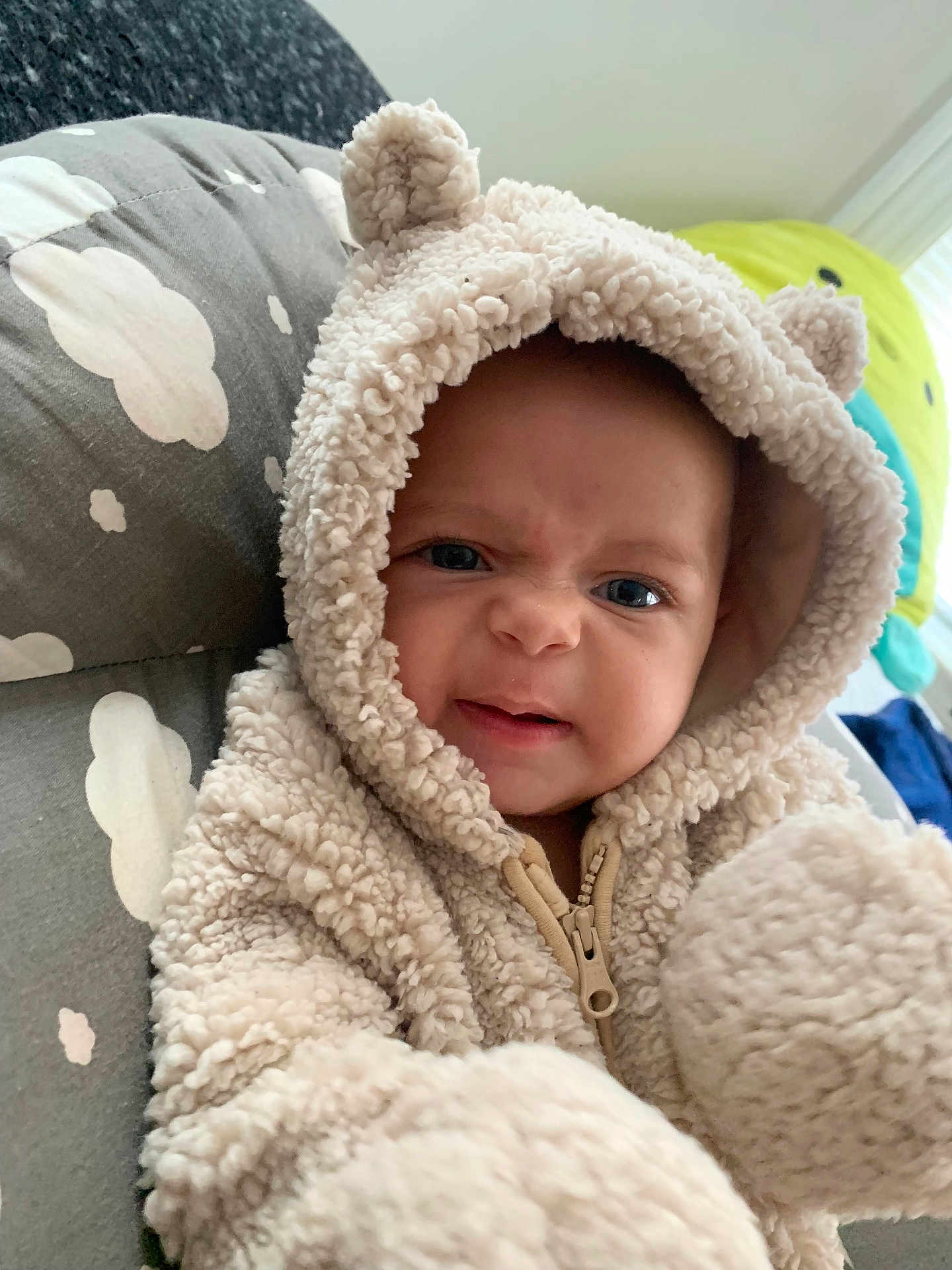 Scarlett joined the competition — help win amazing prizes! baby, child, hoodie, fluffy_clothing, cute, face, expression, indoor, pillow, cloud_pattern, infant, person, warm_clothing, zipper, plush, soft_texture, closeup, portrait, blue_eyes, cozy