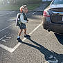 alloywheel, car, carwheel, child, city, clothing, female, footwear, girl, licenseplate, person, road, shoe, shorts, street, tarmac, transportation, urban, vehicle, walking