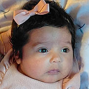 Ella'Cee is registered to the contest to win money with this photo: baby, infant, child, face, pink_bow, dark_hair, big_eyes, cute, portrait, closeup, soft_texture, blanket, clothing, newborn, adorable, skin, expression, lying_down, head, peaceful