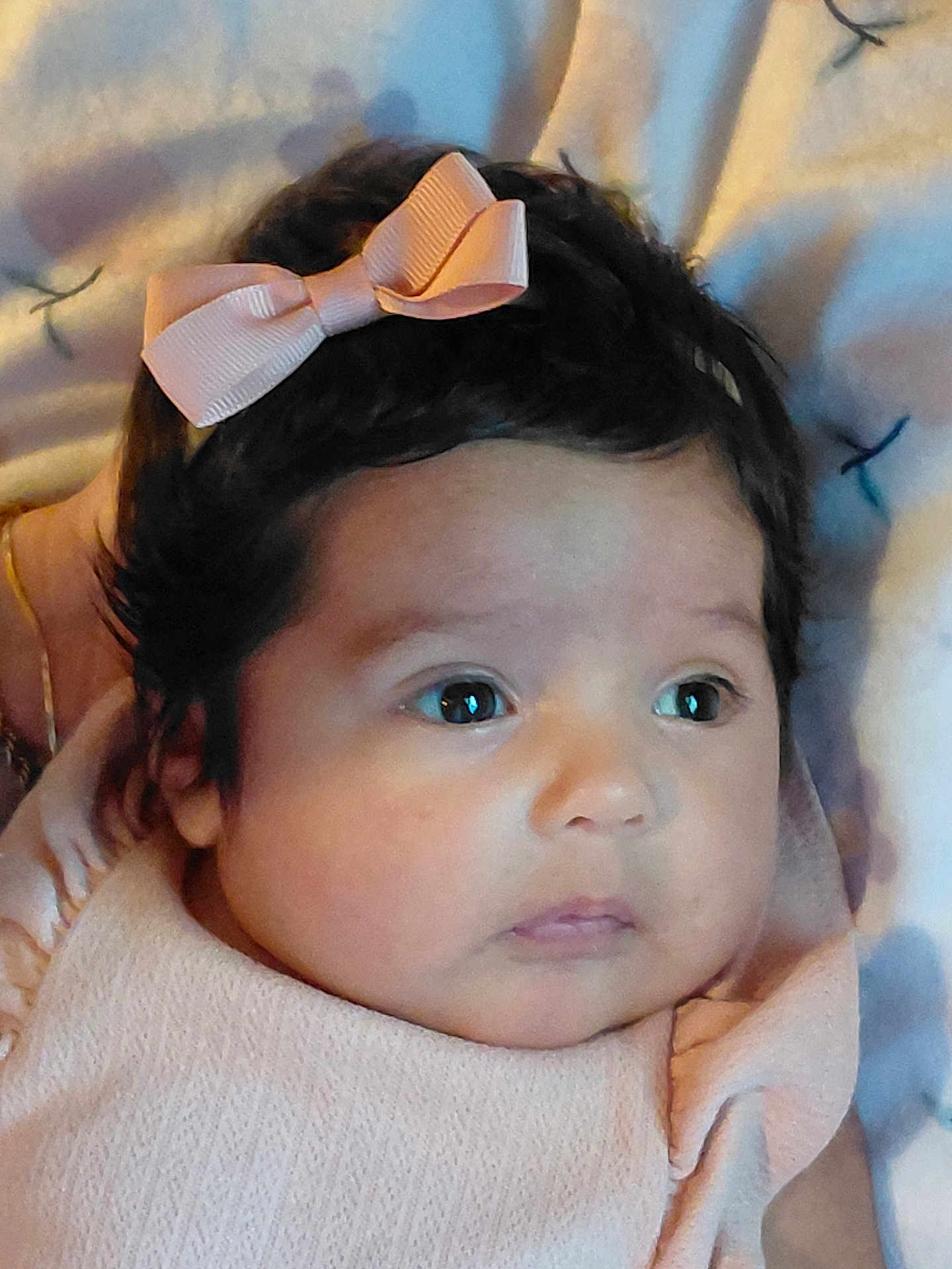 Ella'Cee is registered to the contest to win money with this photo: baby, infant, child, face, pink_bow, dark_hair, big_eyes, cute, portrait, closeup, soft_texture, blanket, clothing, newborn, adorable, skin, expression, lying_down, head, peaceful