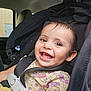 Amelia joined the competition — help win amazing prizes! toddler, child, car_seat, smile, happy, face, clothing, seat_belt, indoors, baby, person, cute, safety_harness, head, car_interior, portrait, young_child, fun, bright_eyes, yellow_dress