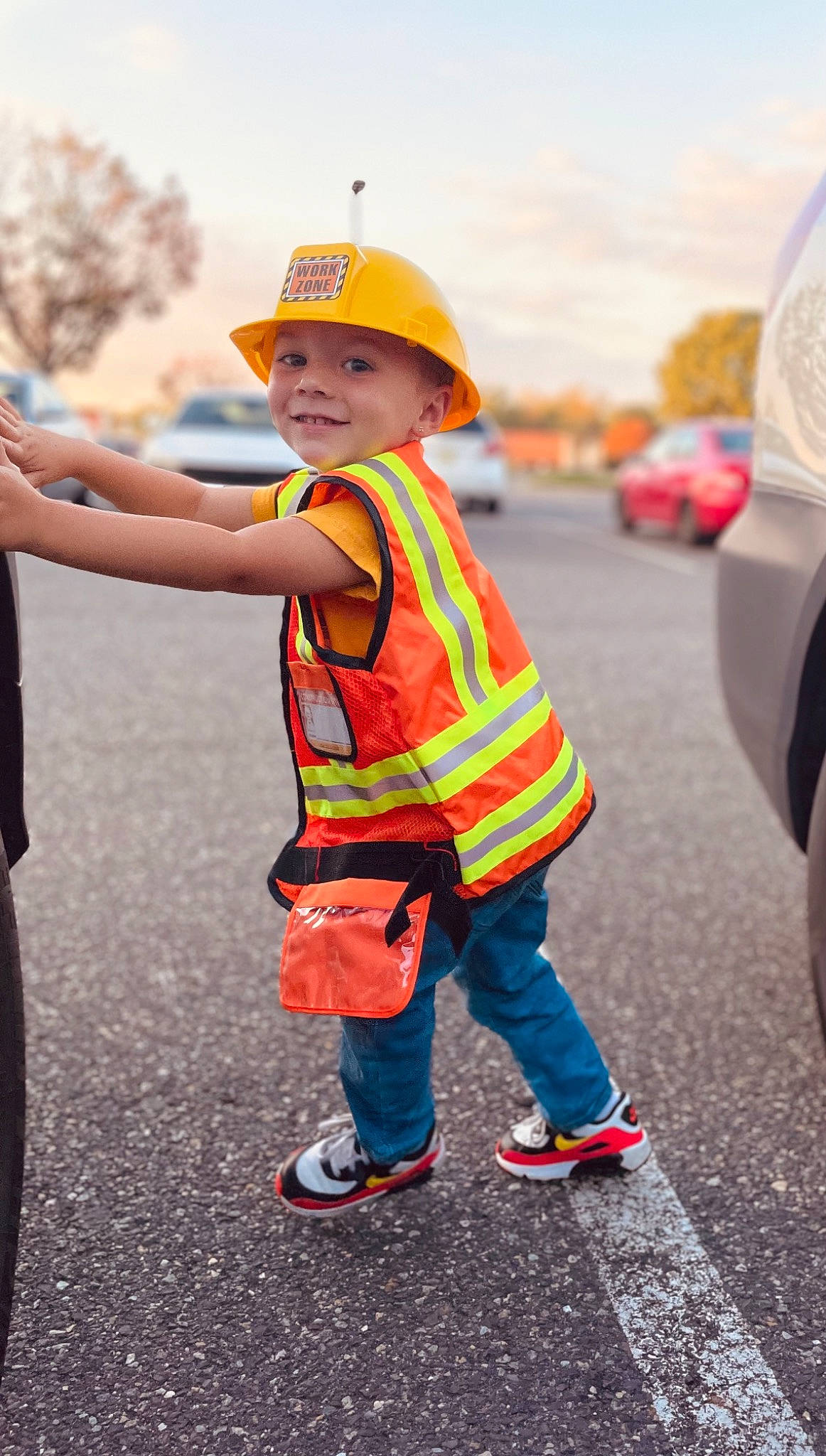 Lucciano is registered to the contest to win money with this photo: asphalt, cap, car, electric_blue, footwear, fun, gesture, happy, hard_hat, headgear, headwear, helmet, joy, leisure, orange, person, personal_protective_equipment, recreation, road_surface, sky