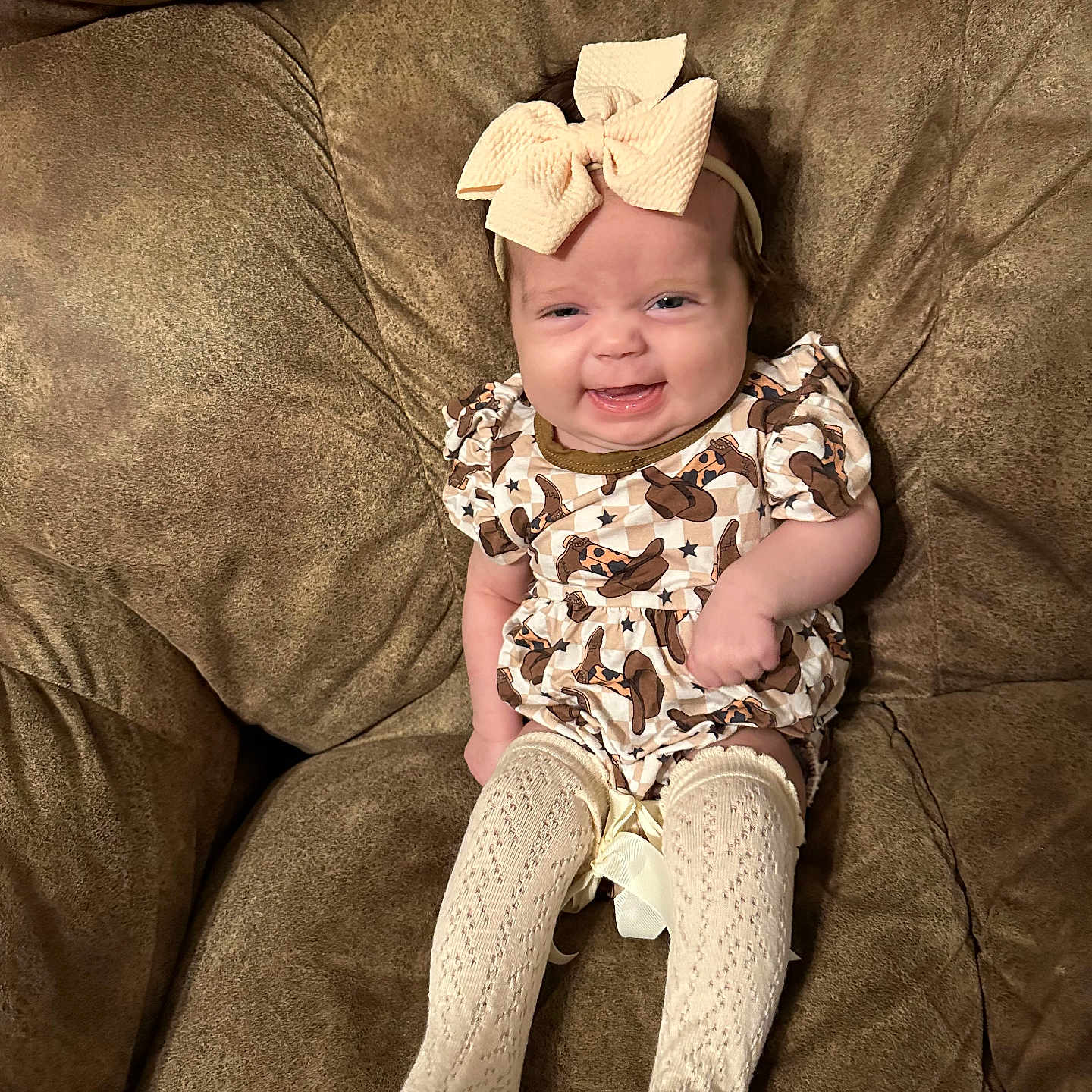 Wrenleigh joined the competition — help win amazing prizes! baby, bow, child, comfort, couch, cozy, cute, dress, furniture, happy, headband, indoor, infant, knit_socks, patterned_clothing, person, sitting, small_person, smile, young_child