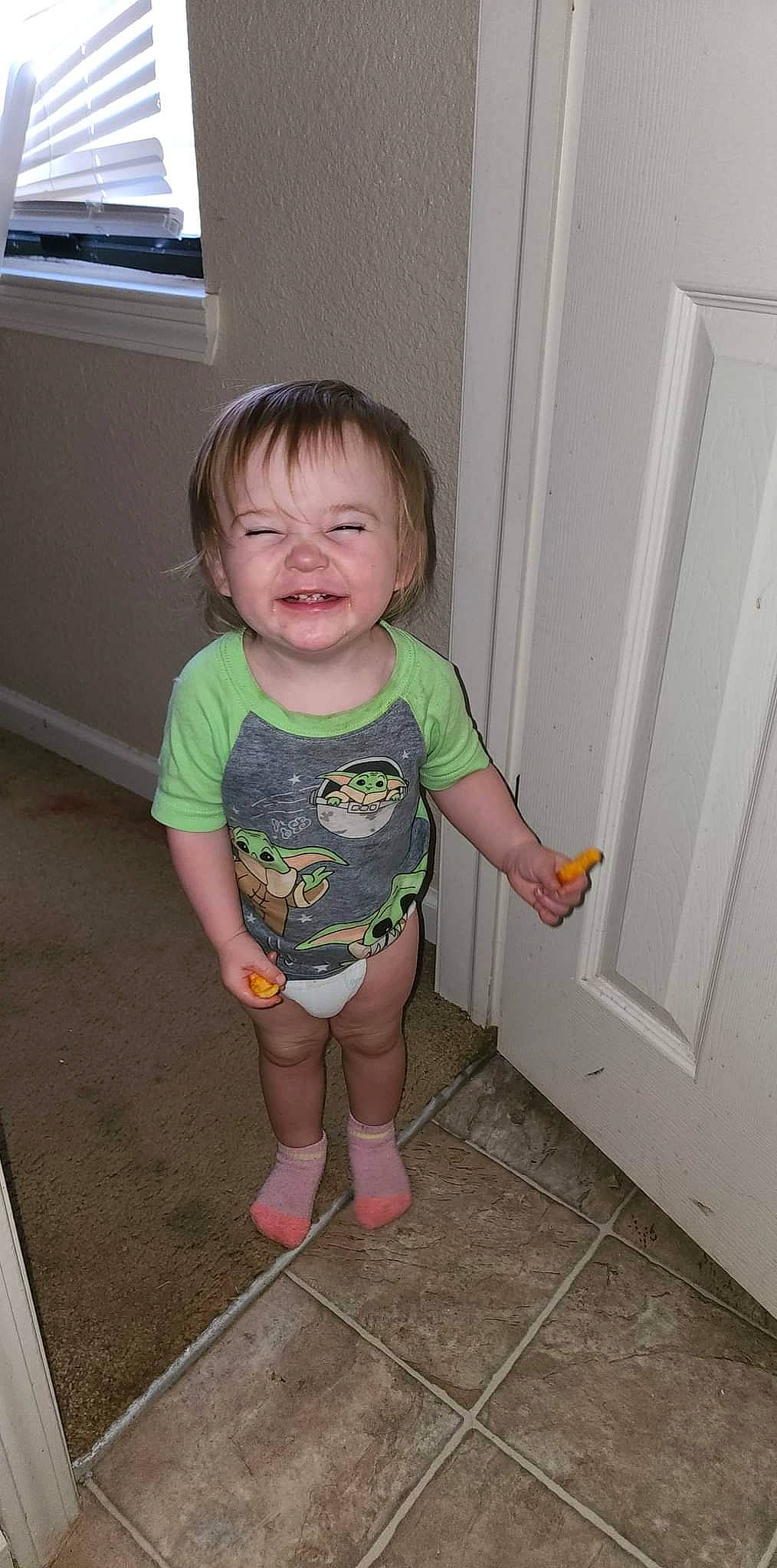 Emmaleigh is registered to the contest to win money with this photo: baby, baby_toddler_clothing, clothing, door, facial_expression, flooring, fun, head, joint, person, pink, product, shoulder, skin, sleeve, smile, standing, television, thigh, toddler