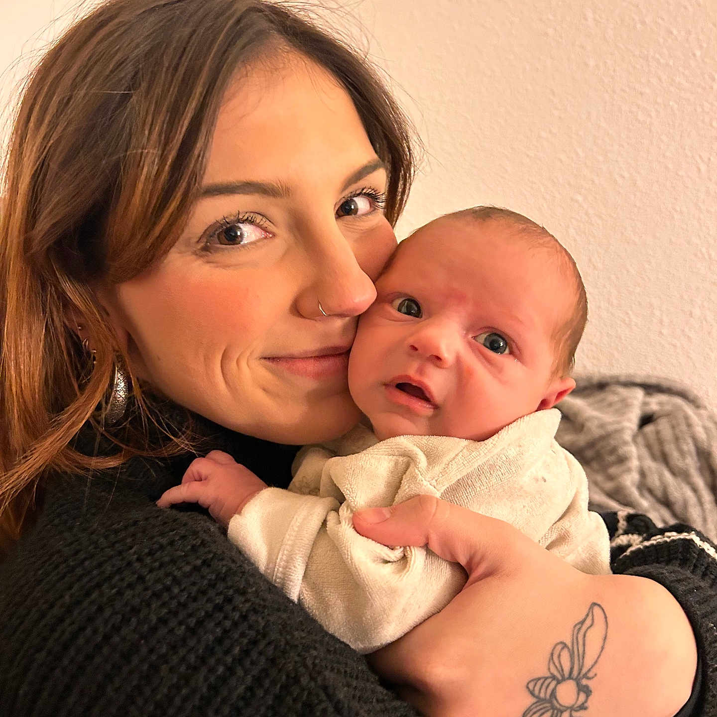 Luciano Ange Milo participe au concours pour gagner de l'argent avec cette photo : baby, black_sweater, clothing, cozy, curious, expression, face, flower_tattoo, holding, hug, indoor, intimate, newborn, nose_ring, person, portrait, skin, tattoo, warmth, woman