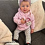 toddler, child, baby, pink_hoodie, leopard_print_leggings, headband, pacifiers, sneakers, couch, pillows, indoor, cute, smiling, sitting, blue_eyes, cozy, soft_lighting, casual_clothing, portrait, happy