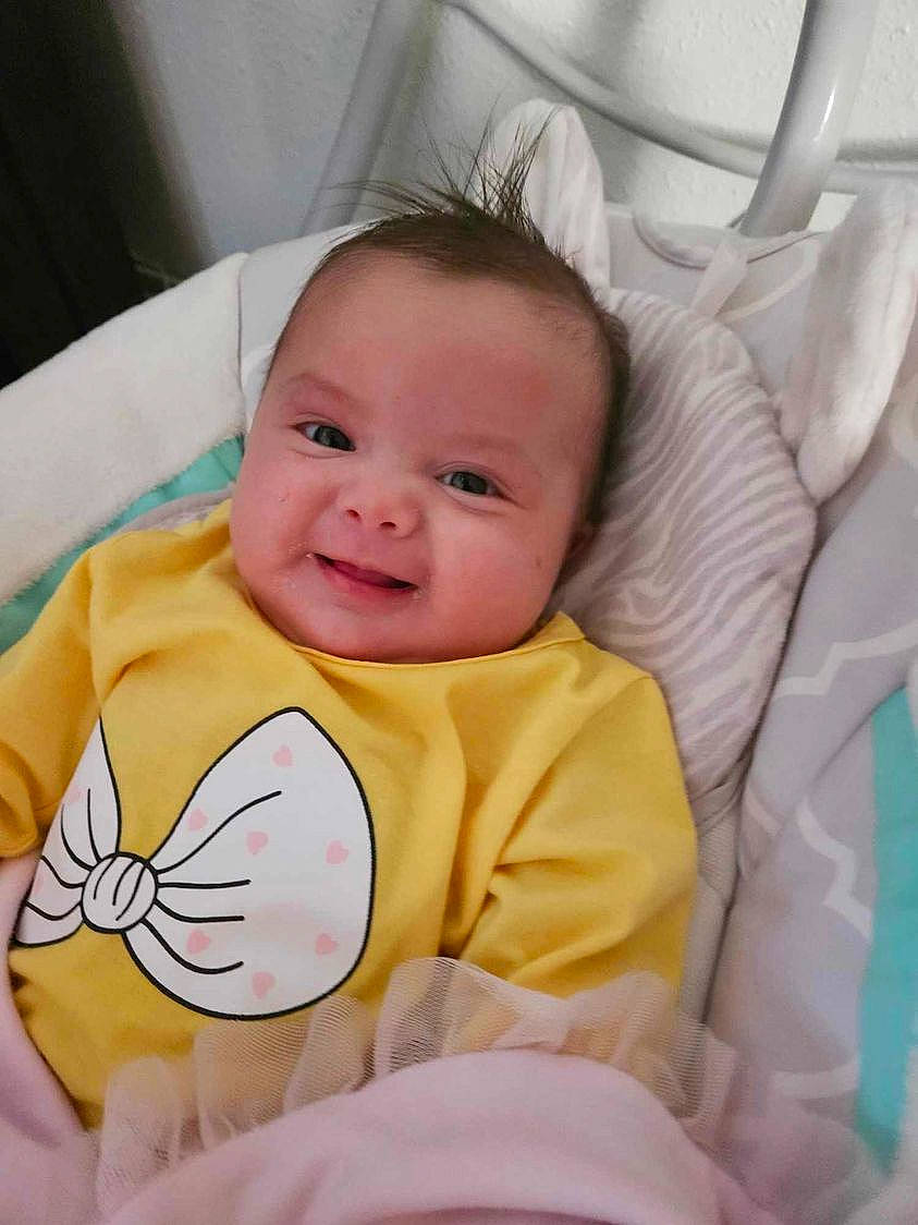 Arabella is registered to the contest to win money with this photo: baby, baby_safety, baby_toddler_clothing, cheek, chin, comfort, eye, eyebrow, face, happy, head, iris, joy, linens, mouth, nose, person, skin, sleeve, smile