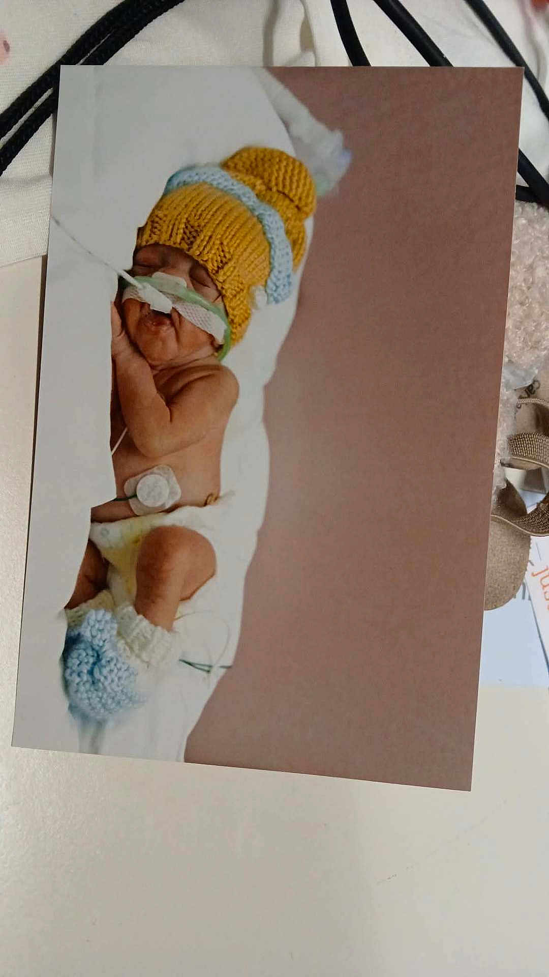 Amari is registered to the contest to win money with this photo: baby, blanket, booties, child, cute, diaper, healthcare, hospital, indoors, infant, knitted_hat, medical_tubes, newborn, peaceful, portrait, resting, sleeping, small, soft, warm_colors