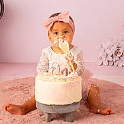 Chiara participe au concours pour gagner de l'argent avec cette photo : baby, child, cake, birthday, pink, headband, dress, frosting, messy, smiling, sitting, spatula, celebration, floor, rug, decorations, flowers, cute, indoors, portrait