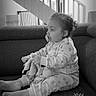 Layana a rejoint le concours — aidez-le/la à gagner de superbes lots ! barefoot, black_and_white, blanket, child, couch, cozy, gaze, hair_bun, indoor, living_room, pacifier, pajamas, portrait, railing, sitting, sofa, staircase, stuffed_toy, timestamp, toddler