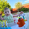 Jenna is registered to the contest to win money with this photo: baby, child, outdoor, play, activity_walker, bib, greenery, fence, sunlight, happy, face, person, toys, grass, sidewalk, nature, summer, expression, young, infant